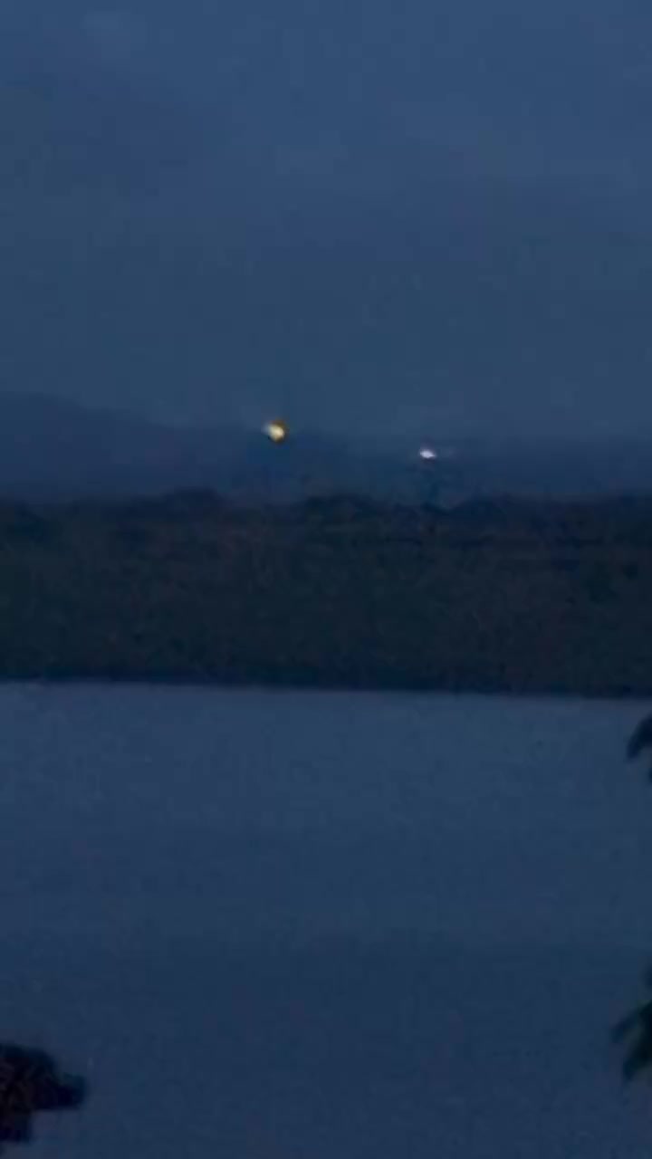 Two small lights above a dark horizon at dusk.