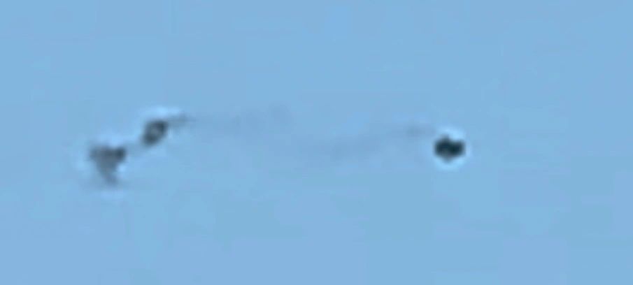 Three blurred, rounded objects against a blue sky in the original photo diary image.